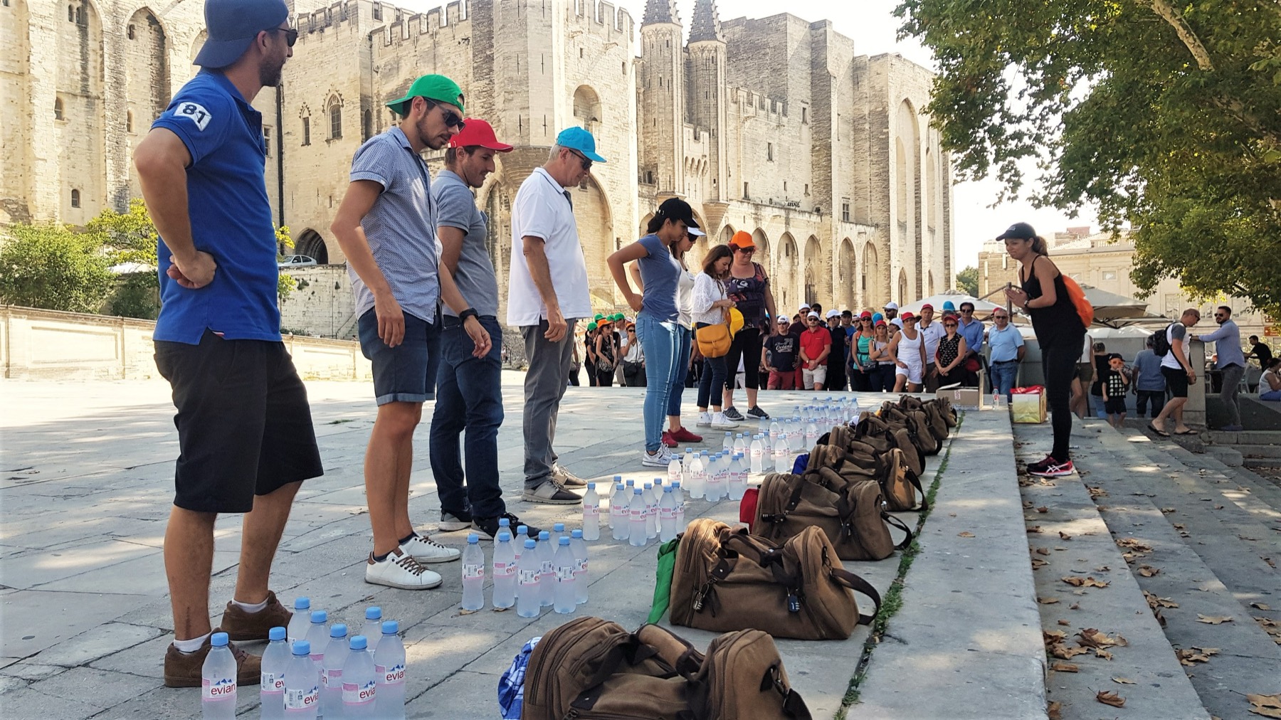 Les sacs à dos d’un escape game alignés devant le Palais des Papes